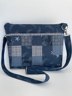 "Discover the \"Miami\" - a multi-pocketed, lightweight shoulder/crossbody bag that gives you plenty of organized space without an oversized look.  This Miami is done in coordinated deep federal blue and white cotton prints.   There are three generous accented exterior pockets - the front pocket composed of a coordinated patchwork of matching blue prints.  On the back are two accented pockets matching the basic bag fabric.    Inside are three slip pockets plus a zippered pocket on a white dot print lining.   The adjustable and detachable shoulder strap can be customized to standard or crossbody lengths.   Comfortably fits the iPad mini tablet (>8\") or standard kindle.  Fully lined.  Top zipper closure.   12\" WIDE // 9\" HIGH // 2\" WIDE  Made with 100% cotton fabrics.   Brushed silver-to Blue Shoulder Bag With Cell Phone Pocket For On-the-go, Navy Shoulder Bag With Zipper Pocket For Travel, Rectangular Shoulder Bag With Flat Pocket For On-the-go, Navy Crossbody Travel Bag, Everyday Rectangular Shoulder Bag With Flat Pocket, Rectangular Blue Shoulder Bag With Pockets, Versatile Blue Shoulder Bag With Pockets, Navy Crossbody Shoulder Bag With Removable Pouch, Blue Rectangular Shoulder Bag With Pockets