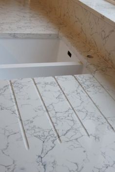 a marble counter top in a bathroom with no shower curtain or tub cover on it