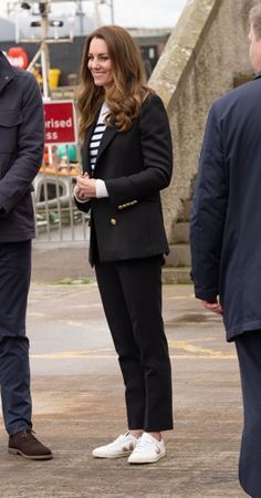 a man and woman standing next to each other in front of some people on the street