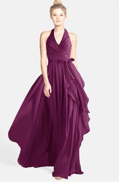 a woman in a long purple dress with a halt neckline and ruffled skirt