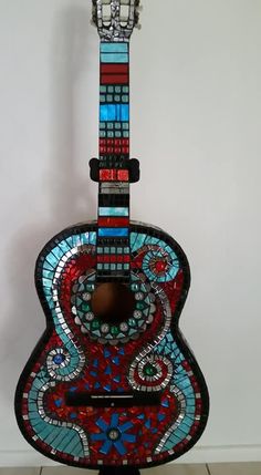 a stained glass guitar sitting on top of a stand