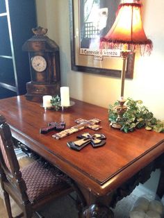 a wooden table topped with a cross next to a lamp