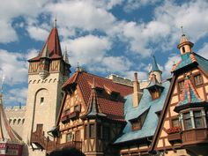 a castle like building with many windows and towers on the top floor, under a cloudy blue sky