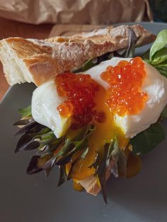 a sandwich with an egg and orange jelly on it is sitting on a blue plate