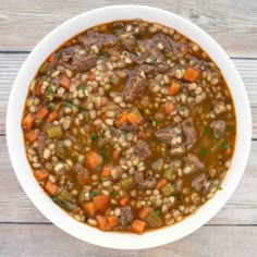 a white bowl filled with soup on top of a wooden table