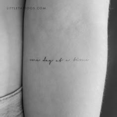 two women's legs with the words one day at a time written on them