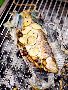 grilled fish with lemon slices and onions on the grill