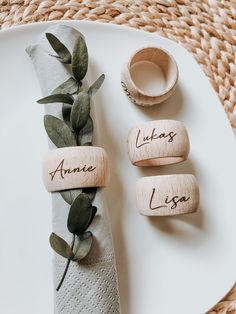 place setting with napkins and wooden name tags on them, including an olive branch