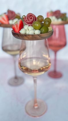 three wine glasses filled with different types of food