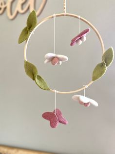 a handmade mobile with pink, white and green felt butterflies