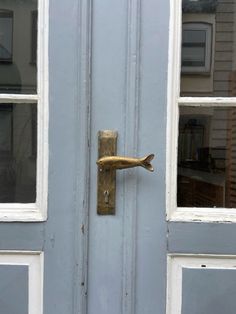 a blue door with a gold handle and fish finial on the front part of it