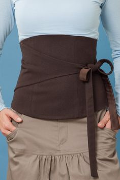 an image of a woman wearing a waist belt with her hands on her hip and the bottom half of her stomach