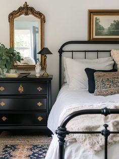 a bedroom with a bed, dresser and mirror on the wall next to each other