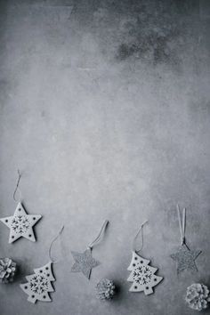 five ornaments hanging from strings on a gray background