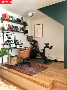 there is a bike sitting on the floor in this home office area with shelves above it