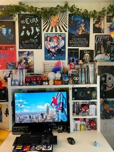 a desktop computer sitting on top of a desk next to a keyboard and mouse in front of a wall covered with posters