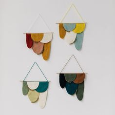 three wall hangings made out of felt with different colors and shapes on the sides