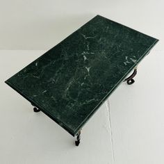 a green marble top coffee table on casteors