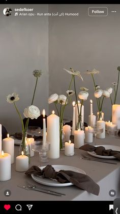 a table topped with lots of white flowers and candles