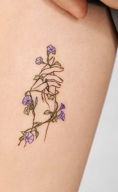 a woman's thigh with tattoos on it and flowers growing out of the side