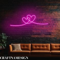 a couch sitting in front of a brick wall with a neon sign above it that says craftma design