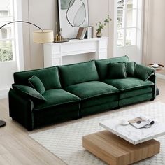 a green couch sitting on top of a hard wood floor next to a coffee table