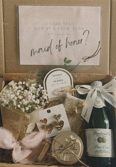 a box filled with lots of wine and other items next to a sign that says, now is your time maid of honar