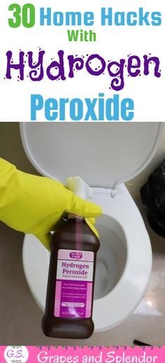 a person in yellow gloves cleaning a toilet with hydrogen peroxide on the lid