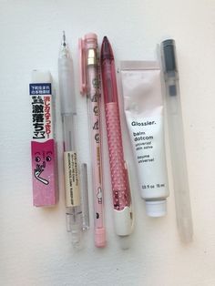 several different types of toothbrushes, lip balm, and other items on a white surface