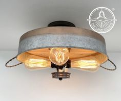 an industrial style light fixture with two lights on the bottom and one bulb turned on