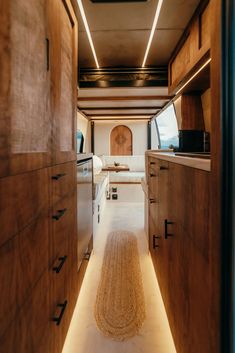 the interior of a camper with wood cabinets and white counter tops is lit by recessed lighting