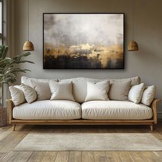 a living room scene with focus on the couch and large painting hanging above it's head