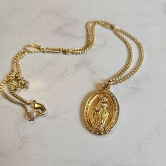 "This beautiful necklace features a stunning gold Italian Miraculous Medal on an 18\" chain. I have been making rosaries for decades, taught by one of the best crafters in the field. This rosary is handmade using a time-tested, intricate wire-wrapping technique, so it extremely durable meant to last a lifetime. It makes a truly meaningful gift for a baptism, wedding, or other faith celebration. DETAILS ⚬ Gold Italian Miraculous Medal ⚬ 18\" Chain ⚬ Includes free prayer card. ⚬ Free shipping. ⚬ M Gold-tone Oval Necklace For Gift, Vintage Gold Plated Medallion Necklace As Gift, Vintage Gold Plated Medallion Necklace For Gift, Vintage Gold Plated Medallion Necklace Gift, Gold Spiritual Jewelry And Charms For Blessing, Gold-tone Spiritual Necklace For Gifts, Nickel-free Gold Spiritual Necklaces, Vintage Nickel-free Crucifix Necklace, Vintage Gold Rosary With Crucifix