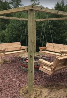 a wooden swing set sitting next to a fire pit