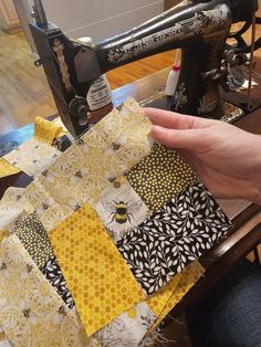 a person is sewing on a machine with yellow and black fabrics in front of them