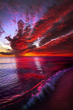 the sun is setting over the ocean with pink and purple clouds