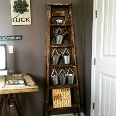 an old ladder is used as a shelf for buckets and other items in this room