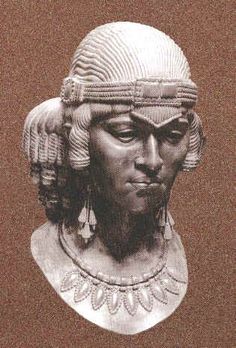 an old photo of a bust of a man with long hair and wearing a headdress