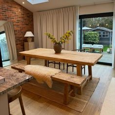 a dining room table and bench in front of a sliding glass door that leads to an outside patio