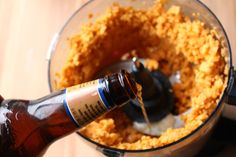 a bottle of beer being poured into a food processor