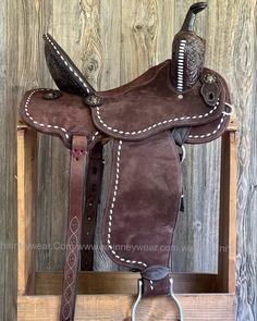 a close up of a saddle on a wooden stand