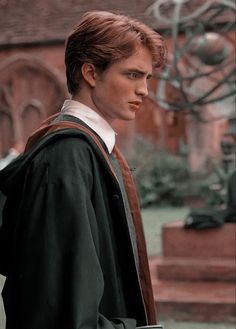 a young man is standing in front of a statue