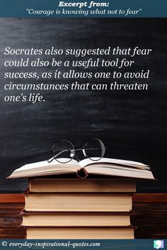 an open book sitting on top of a pile of books next to a blackboard