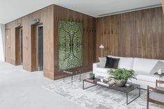 a living room with wood paneling and white furniture