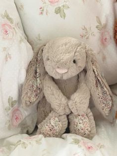 a stuffed rabbit sitting on top of a bed