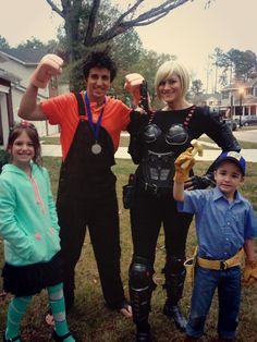 three people dressed in costumes posing for a photo with one person holding up his fist