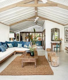 a living room filled with furniture and a wooden table on top of a carpeted floor