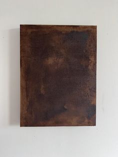 a square piece of wood hanging on the wall