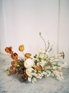 an arrangement of flowers on a marble surface