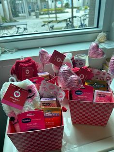 several valentine's day gift baskets on a window sill in front of a large window